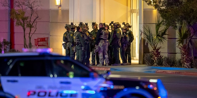 Police officers gather at an entrance of a shopping mall, Wednesday, Feb. 15, 2023, in El Paso, Texas.  