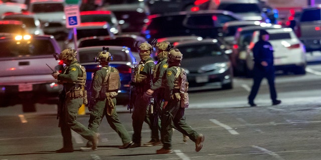 Law enforcement agents walk in the parking lot of a shopping mall, Wednesday, Feb. 15, 2023, in El Paso, Texas. 