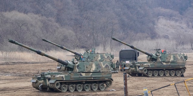 South Korean army soldiers work by K-9 self-propelled howitzers in Paju, South Korea, near the border with North Korea, Thursday, Feb. 16, 2023.