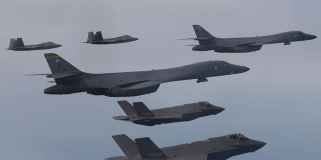 In this photo provided by South Korean Defense Ministry, U.S. Air Force B-1B bombers, center, F-22 fighter jets and South Korean Air Force F-35 fighter jets, bottom, fly over South Korea Peninsula during a joint air drill in South Korea, on Jan. 1, 2023. 