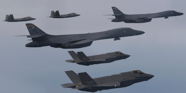 In this photo provided by South Korean Defense Ministry, U.S. Air Force B-1B bombers, center, F-22 fighter jets and South Korean Air Force F-35 fighter jets, bottom, fly over South Korea Peninsula during a joint air drill in South Korea, on Jan. 1, 2023. 