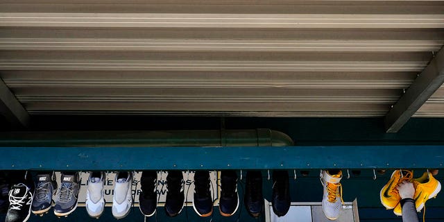 An attendant lowers Pittsburgh Pirates shoes for cleaning during spring training Saturday, February 18, 2023, in Bradenton, Florida.