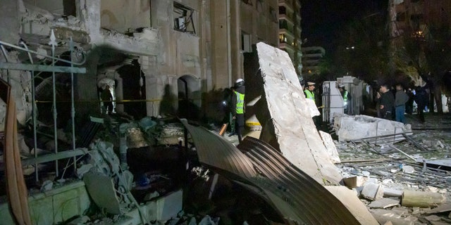 In this photo released by the Syrian official news agency SANA, people view the damage in residential neighborhood after an early morning Israeli airstrike in Damascus, Syria, Sunday, Feb. 19, 2023. (AP)