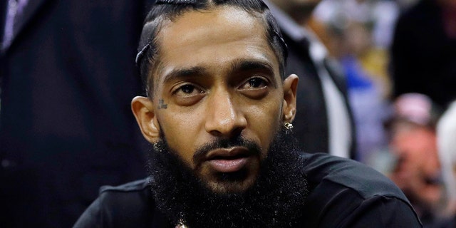 FILE - Rapper Nipsey Hussle attends an NBA basketball game between the Golden State Warriors and the Milwaukee Bucks in Oakland, Calif., March 29, 2018. 