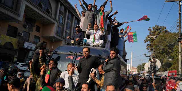 La policía pakistaní arresta a un general retirado del ejército acusado de incitar al público contra las instituciones nacionales 4 Los partidarios del ex primer ministro paquistaní Imran Khan se suben a un coche de policía durante una manifestación en Lahore, Pakistán, el 22 de febrero de 2023. El ex general del ejército Amjad Shoaib ha sido arrestado acusado de incitar al público contra las instituciones nacionales.