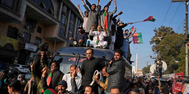 Supporters of Pakistan's former Prime Minister Imran Khan climb on a police van during a rally, in Lahore, Pakistan, on Feb. 22, 2023. Former Army Gen. Amjad Shoaib was arrested for inciting the public against national institutions.