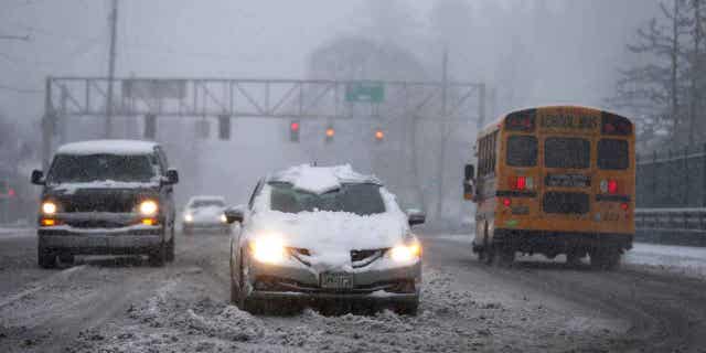 Vehicles drive on an overpass at Interstate 5 during a snowstorm on Feb. 22, 2023, in Portland, Oregon. The storm is expected to sweep through California in the coming days.