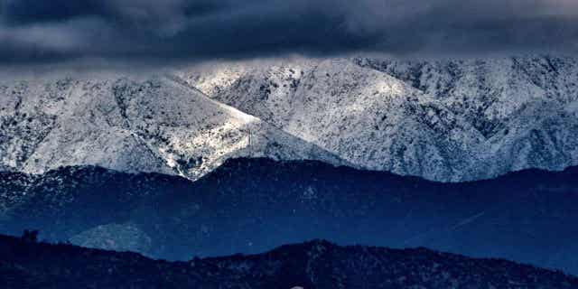Storm clouds and snowfall are seen complete nan San Gabriel upland scope successful Los Angeles connected Feb. 26, 2023. A wintertime large wind that swept nan West Coast pinch flooding and frigid temperatures has shifted to confederate California.