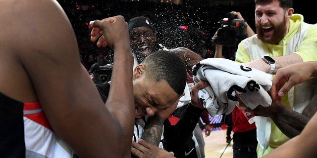 Portland Trail Blazers guard Damian Lillard, center, is doused by teammates after setting franchise and career highs with 71 points during an NBA basketball game against the Houston Rockets in Portland, Oregon, Sunday, Feb. 26, 2023. 