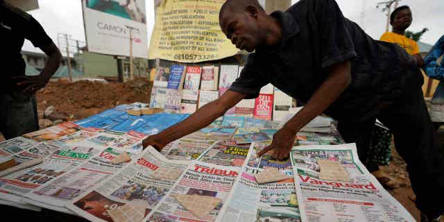 A man arranges section newspapers pinch nan preliminary statesmanlike predetermination results connected a thoroughfare successful Nigeria connected Feb. 27, 2023.