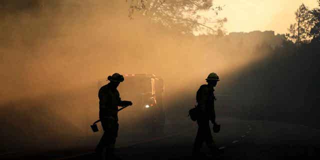 Two firefighters watch for spot fires on Oct. 13, 2017, near Calistoga, California. Columbia University scientists warned that the record-breaking heat in 2022 is set return this year.