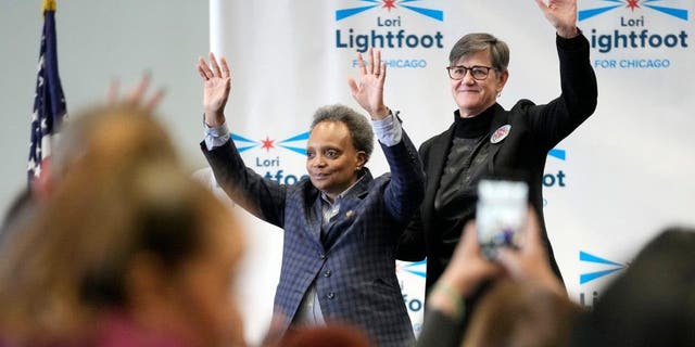 Chicago Mayor Lori Lightfoot, left, and her spouse Amy Eshleman wave to supporters during a Women for Lori rally in Chicago Saturday, Feb. 25, 2023.