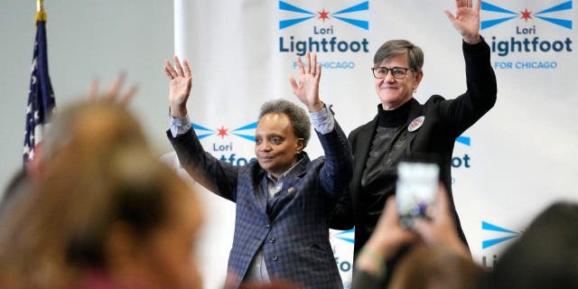 Chicago mayor Lori Lightfoot, left, and her spouse Amy Eshleman wave to supporters during Women for Lori Rally in Chicago, Saturday, Feb. 25, 2023.