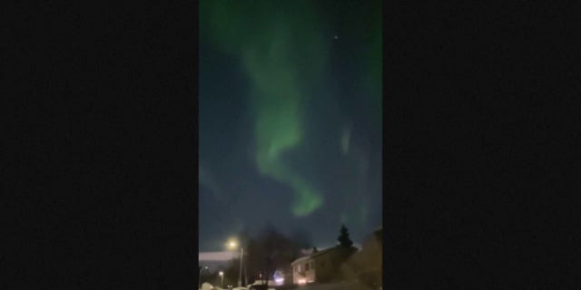 Cahaya utara menyilaukan langit di atas Anchorage, Alaska, Minggu.