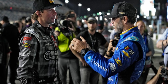 Jimmie Johnson, right, and Travis Pastrana talk before qualifying for the NASCAR Daytona 500 auto race Wednesday, Feb. 15, 2023, at Daytona International Speedway in Daytona Beach, Fla.