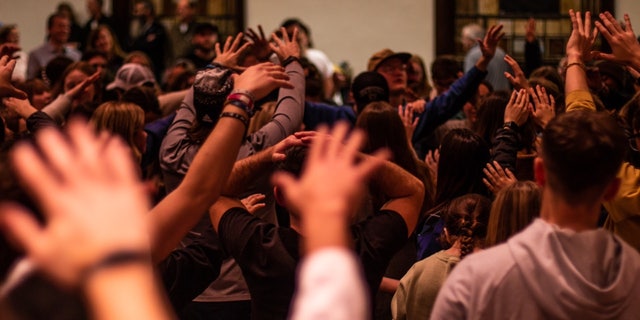 Worshipers raise their hands during a service at Asbury University Chapel in Wilmore, Kentucky.