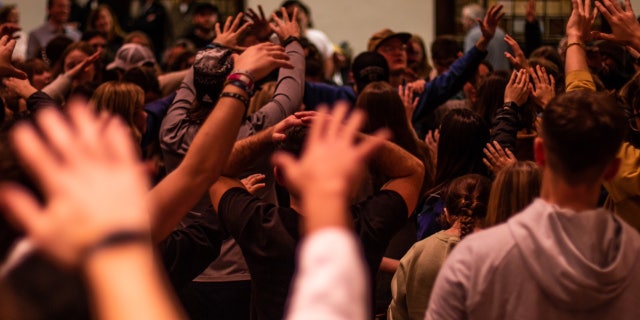 Worshipers lift their hands during a service in the chapel of Asbury University in Wilmore, Kentucky.