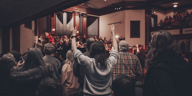 Students raise their hands during a service in the chapel at Asbury University, which has seen participants flocking in nationwide to witness its revival.