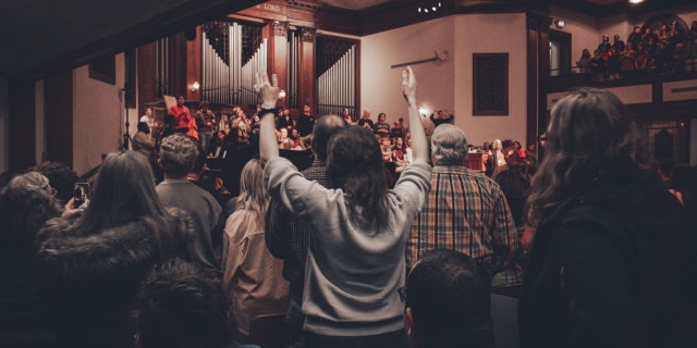 Students raise their hands during a service in the chapel at Asbury University, which has seen participants flocking in nationwide to witness its revival.