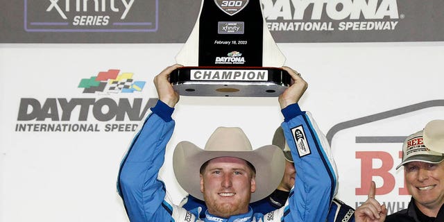 Austin Hill lifts the trophy in victory lane after winning the NASCAR Xfinity Series Beef. It's What's For Dinner. 300 on Feb. 18, 2023, in Daytona Beach, Florida.