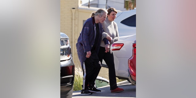 Ozzy Osbourne, left, keeps fit at LA fitness class after shooting mega-bucks Super Bowl commercial. Osbourne appeared to struggle to walk on his own and was assisted out by his personal trainer to a waiting limo.