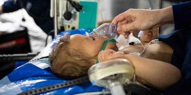 A baby with respiratory issues is cared for by a Samaritan's Purse nurse at a field hospital set up by the organization in Antakya, Turkey. 