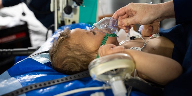 A baby with respiratory issues is cared for by a Samaritan's Purse nurse at a field hospital set up by the organization in Antakya, Turkey.