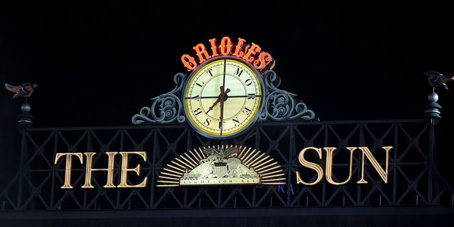 The Sun logo and the Baltimore Orioles clock are shown above the Camden Yards scoreboard Sept. 30, 2021.