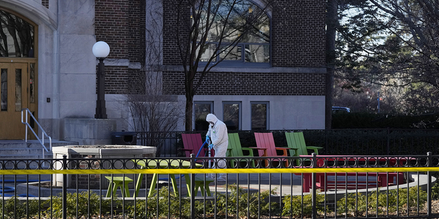 A worker cleans outside Burke Hall at Michigan State University Tuesday, February 14, in East Lansing, Michigan.