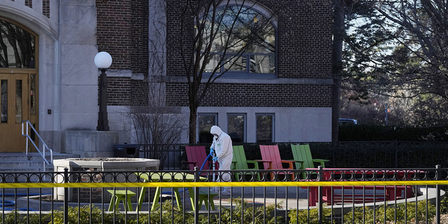 A worker cleans up outside Berkey Hall at Michigan State University, Tuesday, Feb. 14, in East Lansing, Michigan.