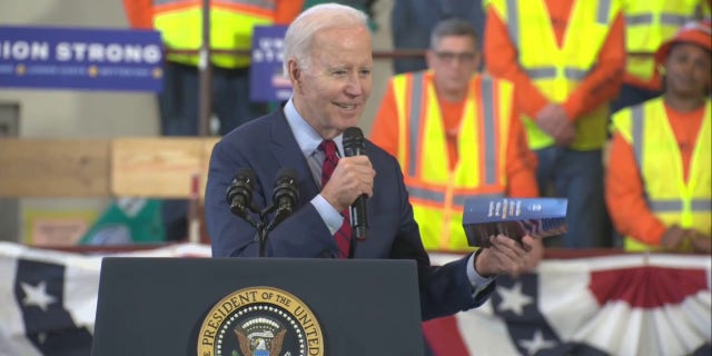 President Biden holds a copy of a Sen. Rick Scott proposal during a speech Wednesday, Feb. 8, 2023, in Wisconsin.