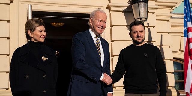 President Biden, center, shakes hands with Ukrainian President Volodymyr Zelenskyy, right, as they pose with Olena Zelenska, left, spouse of President Zelenskyy, at Mariinsky Palace during an unannounced visit in Kyiv, Ukraine, Monday, Feb. 20, 2023. 