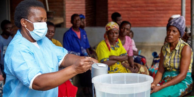 Violett Motta, a health surveillance assistant in Malawi, mixes chlorine with water to disinfect it at a health centre in response to the latest cholera outbreak in Blantyre, Malawi, on Nov. 16, 2022. 