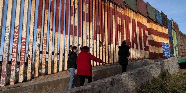 People walk near the US-Mexico border wall at Friendship Park before being replaced in Playas de Tijuana, Baja California state, Mexico, on Feb. 16, 2023.