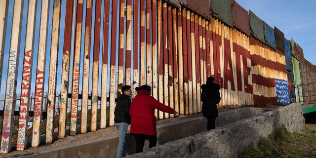 People walk near the U.S.-Mexico border wall at Friendship Park before being replaced in Playas de Tijuana, Baja California state, Mexico, on Feb. 16, 2023.