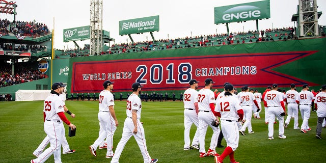 Members of the Boston Red Sox walk toward the outfield during a 2018 World Series championship ring ceremony before an opening day game against the Toronto Blue Jays April 9, 2019, at Fenway Park in Boston.
