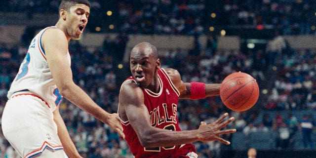 Michael Jordan, left, working his way around Brad Daugherty, heads toward the basket in first half action at the Coliseum.