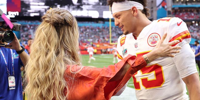 Brittany Mahomes and Patrick Mahomes hug on the field before Super Bowl LVII on February 12, 2023 at State Farm Stadium.