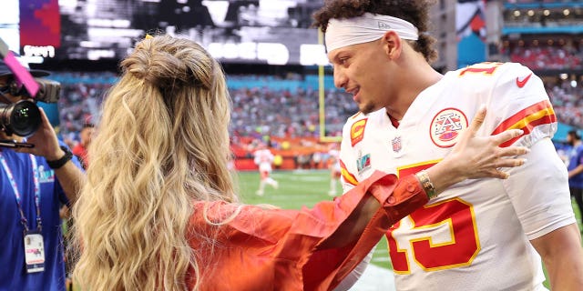 Brittany Mahomes and Patrick Mahomes embrace on the field before Super Bowl LVII at State Farm Stadium on Feb. 12, 2023.