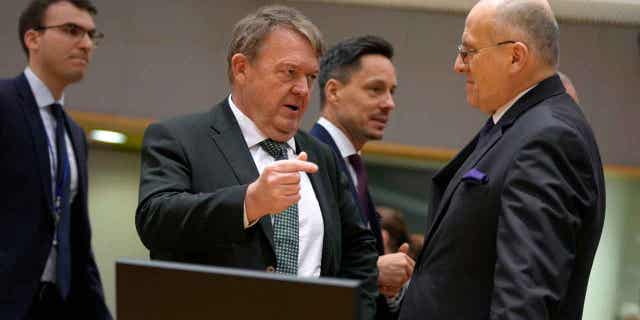 Denmark's Foreign Minister Lars Lokke Rasmussen, center, speaks with Poland's Foreign Minister Zbigniew Rau, right, in Brussels on Feb. 20, 2023. European Union foreign ministers imposed sanctions on nine Burma officials linked to rising violence and human rights violations.