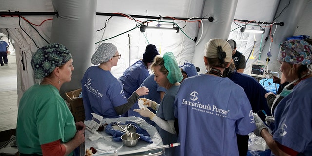 Perawat Samaritan's Purse berkumpul untuk membantu pasien yang terluka akibat gempa bumi.