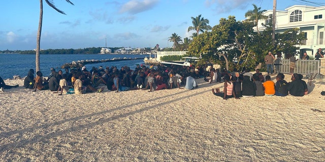 Haitian migrants sitting on beach