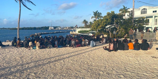 Haitian migrants sitting on beach