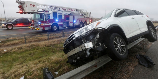 A vehicle rests on a barricade as the driver lost control and slid off Highway 6 on Tuesday Jan. 31, 2023 in Waco, Texas. Winter weather brought ice to Texas and nearby states Tuesday.