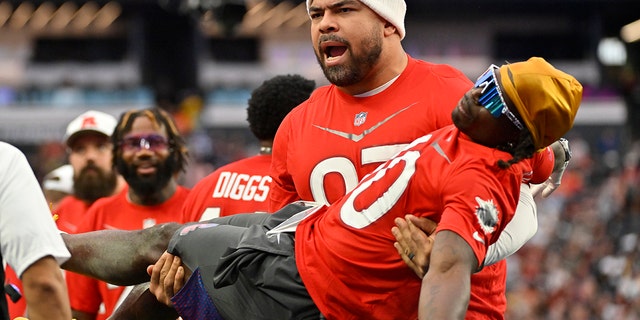 AFC defensive tackle Cameron Heyward of the Pittsburgh Steelers carries AFC wide receiver Tyreek Hill of the Miami Dolphins during the flag football event at the Pro Bowl Games, Feb. 5, 2023, in Las Vegas.