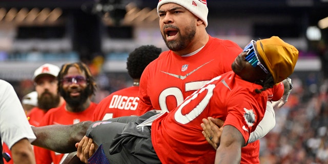 El tackle defensivo de la AFC, Cameron Heyward, de los Pittsburgh Steelers, lleva al receptor abierto de la AFC, Tyreek Hill, de los Miami Dolphins, durante el evento de flag football en el Pro Bowl de la NFL contra la NFC, el domingo 5 de febrero de 2023 en Las Vegas.