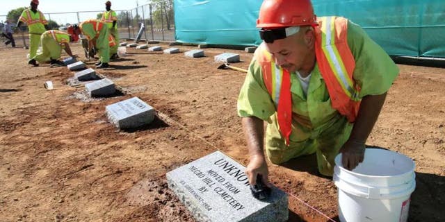 Steven Abujen, a California prison inmate with the Prison Industry Authority, cleans one of the newly installed headstones at the Mormon Island Relocation Cemetery, near Folsom, Calif., on Oct. 18, 2011. Lawmakers in Nevada and California are advancing legislation to remove involuntary servitude from their state constitutions, a move that follows four states that purged forced labor from the books in ballot measures last fall.