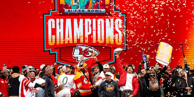 Patrick Mahomes holds up the MVP trophy as he celebrates with teammates during the Chiefs' Super Bowl LVII victory parade on February 15, 2023 in Kansas City, Missouri.