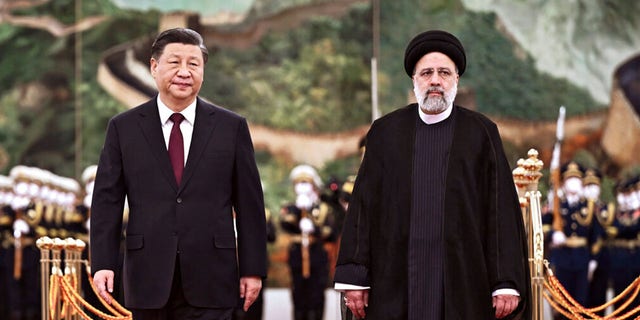 Presiden Iran Ebrahim Raisi berjalan dengan Presiden China Xi Jinping setelah meninjau pasukan kehormatan di Aula Besar Rakyat di Beijing, 14 Februari 2023.