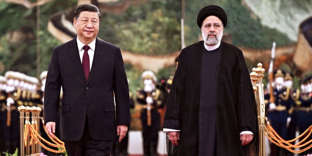 Iranian President Ebrahim Raisi walks with Chinese President Xi Jinping after reviewing an honor guard at the Great Hall of the People in Beijing, Feb. 14, 2023.